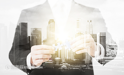 人商業(yè)管理的密切的商人與拼圖城市與雙重曝光商人與拼圖碎片